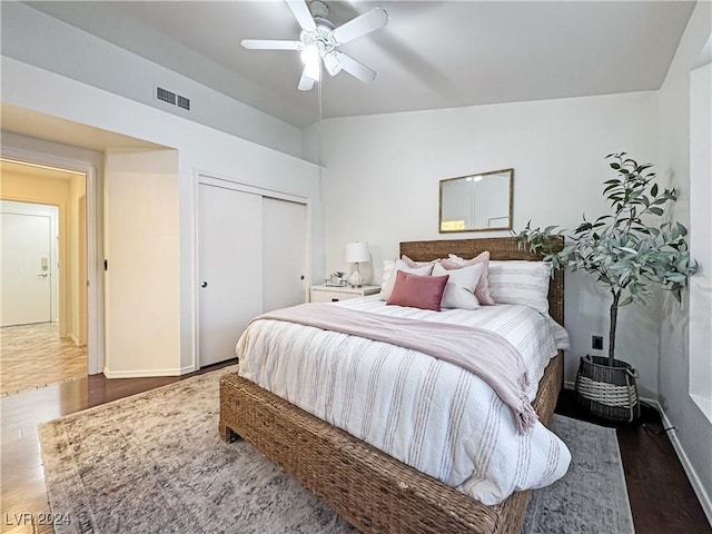 bedroom with a closet, visible vents, ceiling fan, and wood finished floors