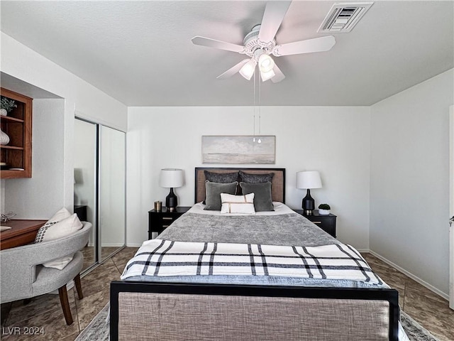 bedroom with ceiling fan, a closet, visible vents, and baseboards