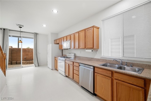 kitchen featuring pendant lighting, white appliances, and sink