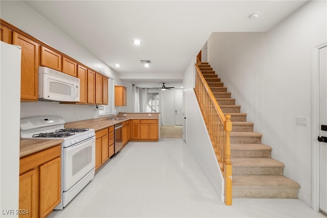 kitchen with kitchen peninsula, light carpet, white appliances, ceiling fan, and sink