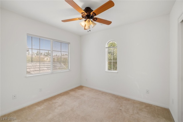 carpeted spare room with ceiling fan