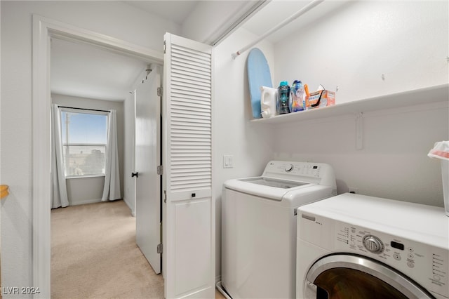 laundry area with washer and dryer and light colored carpet