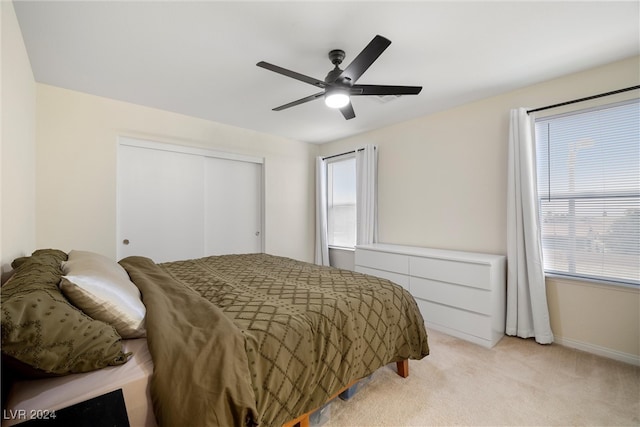 bedroom featuring light carpet, a closet, and ceiling fan