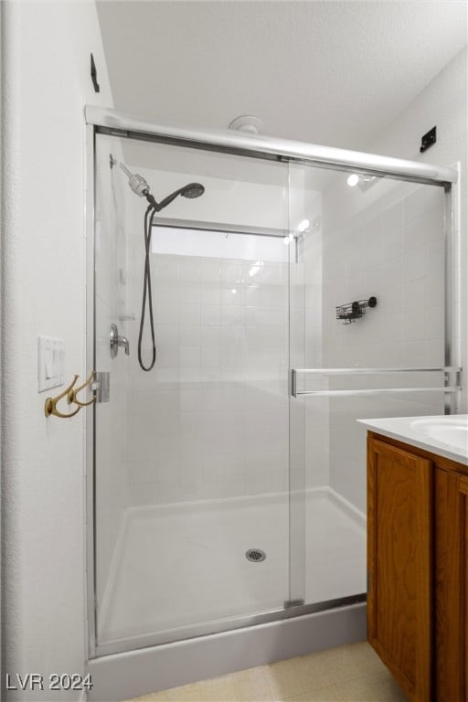 bathroom with vanity and a shower with shower door