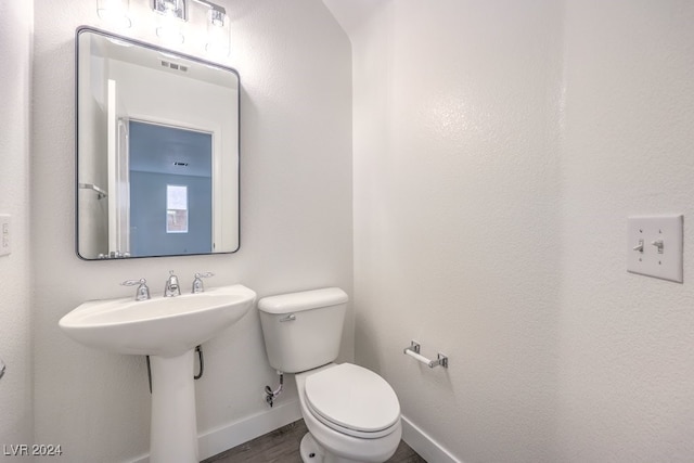 bathroom with hardwood / wood-style flooring and toilet