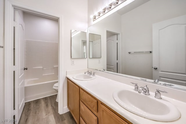 full bathroom featuring hardwood / wood-style floors, vanity,  shower combination, and toilet