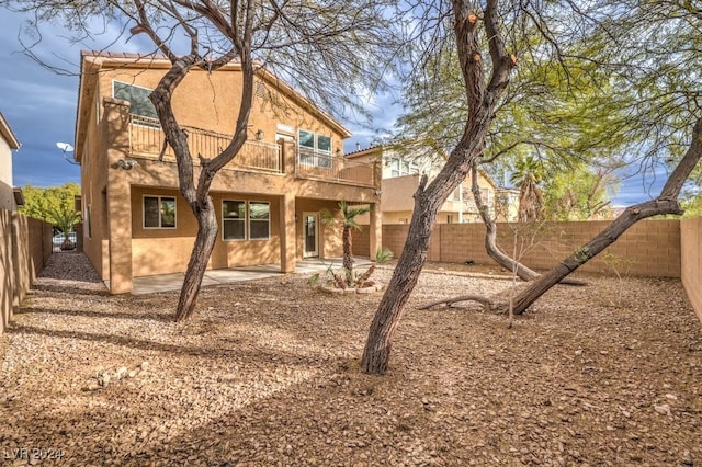 back of property with a patio area and a balcony