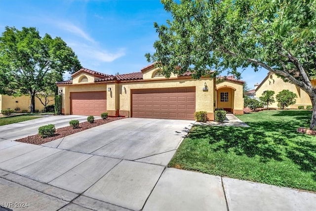 mediterranean / spanish home with a front lawn and a garage