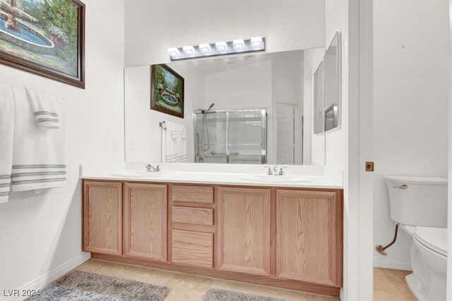 bathroom with tile patterned floors, vanity, toilet, and walk in shower