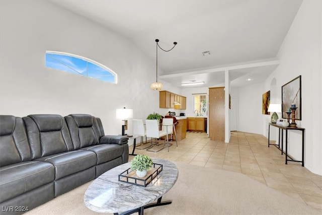 living room featuring light tile patterned floors, lofted ceiling, and sink