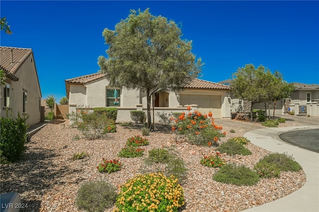 view of front of home with stucco siding, fence, a garage, driveway, and a tiled roof