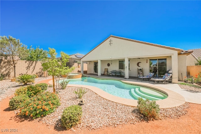 view of pool with a fenced backyard, a pool with connected hot tub, and a patio