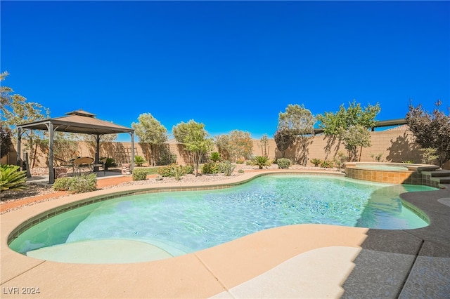 view of swimming pool featuring a fenced backyard, a pool with connected hot tub, and a gazebo