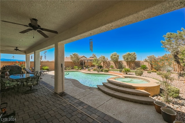 view of swimming pool with ceiling fan, a patio, a fenced backyard, and a pool with connected hot tub