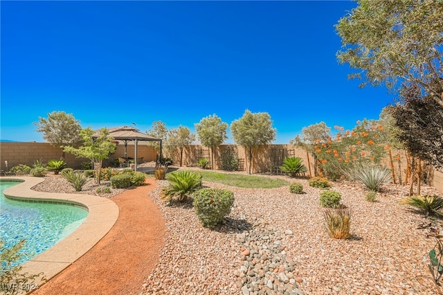 view of yard featuring a fenced in pool, a fenced backyard, and a gazebo