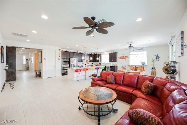 living area with ceiling fan, visible vents, and recessed lighting