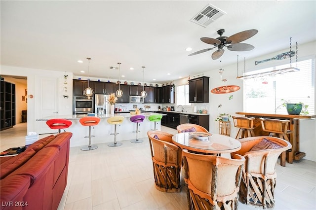 dining room featuring light floors, ceiling fan, visible vents, and recessed lighting