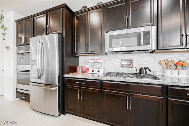 kitchen featuring stainless steel appliances, dark brown cabinetry, and tasteful backsplash