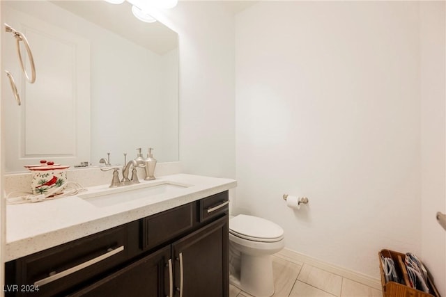 bathroom with baseboards, vanity, and toilet