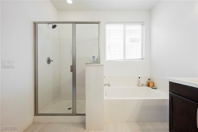 bathroom with a garden tub, a shower stall, and vanity