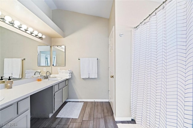 8213 Grassy Point Cir, Las Vegas, NV 89145 - bathroom featuring double vanity, wood finished floors, a shower with curtain, and vaulted ceiling