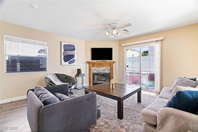 8213 Grassy Point Cir, Las Vegas, NV 89145 - living area with a fireplace, a ceiling fan, and wood finished floors