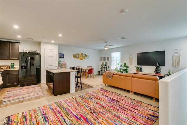 living room with ceiling fan, light wood-type flooring, and sink