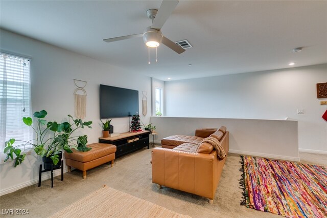 carpeted living room with ceiling fan