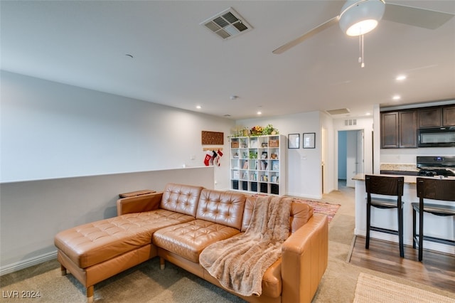 carpeted living room with ceiling fan