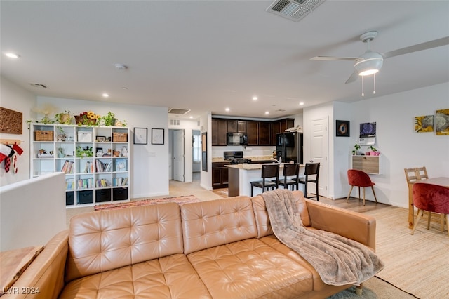 living room with light hardwood / wood-style floors and ceiling fan