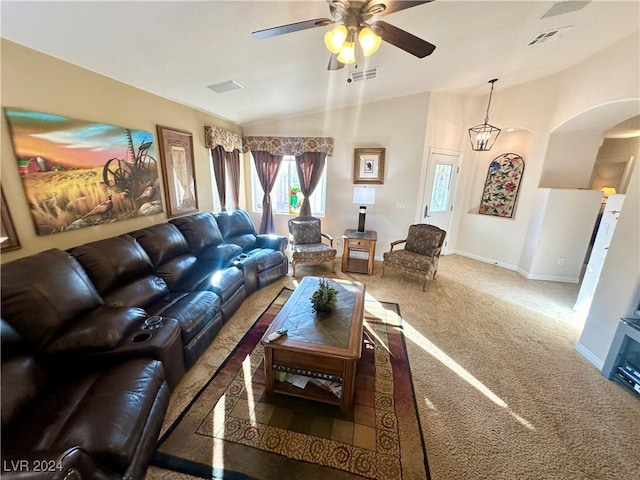 living room with ceiling fan with notable chandelier, carpet, and vaulted ceiling