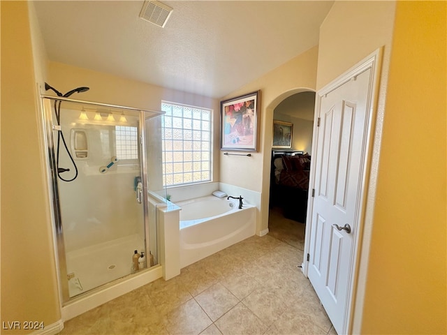 bathroom featuring tile patterned floors, vaulted ceiling, a textured ceiling, and shower with separate bathtub