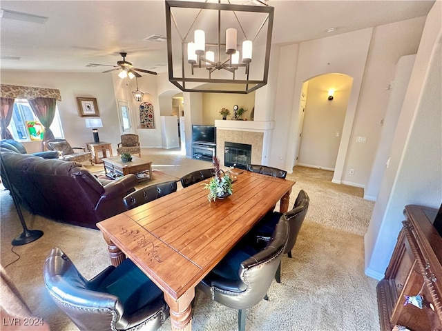 carpeted dining space featuring ceiling fan with notable chandelier