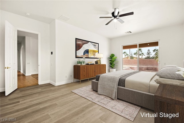 bedroom with access to exterior, hardwood / wood-style floors, and ceiling fan