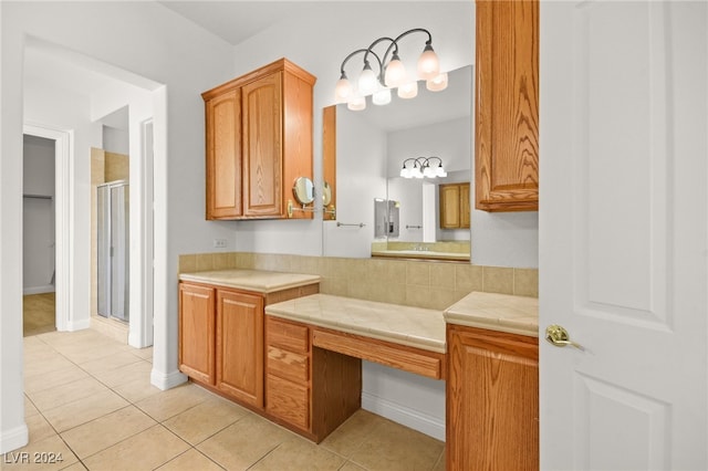 bathroom with tile patterned flooring, vanity, and a shower with door