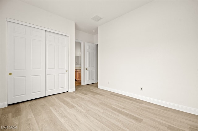 unfurnished bedroom featuring a closet and light hardwood / wood-style floors