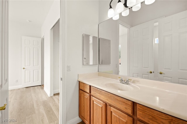 bathroom with a chandelier, hardwood / wood-style floors, and vanity