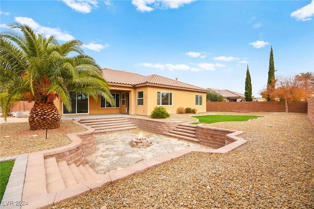 rear view of property with a patio area and an outdoor fire pit