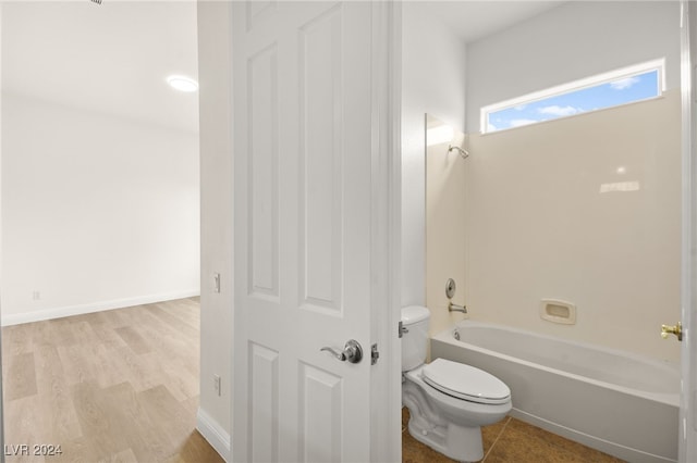 bathroom with toilet, bathtub / shower combination, and hardwood / wood-style flooring