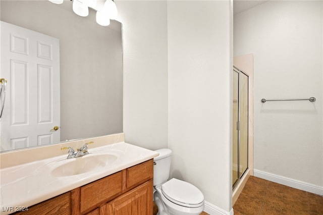 bathroom featuring tile patterned floors, toilet, an enclosed shower, and vanity