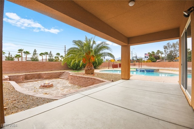 view of patio with a swimming pool with hot tub