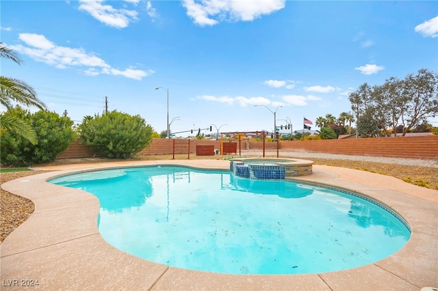 view of pool featuring an in ground hot tub