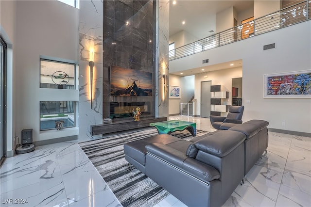 living room with a tiled fireplace and a high ceiling