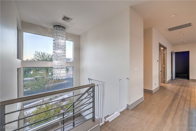 hall featuring light hardwood / wood-style flooring and a notable chandelier