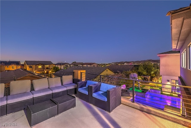 patio terrace at dusk with a balcony and an outdoor hangout area