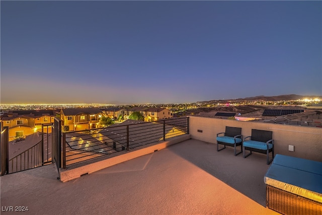 patio terrace at dusk featuring a balcony