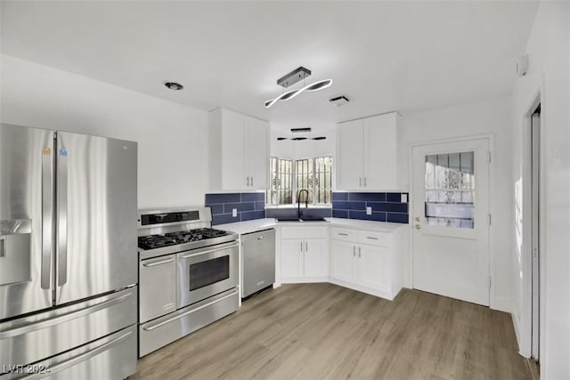 kitchen featuring sink, plenty of natural light, white cabinets, and appliances with stainless steel finishes