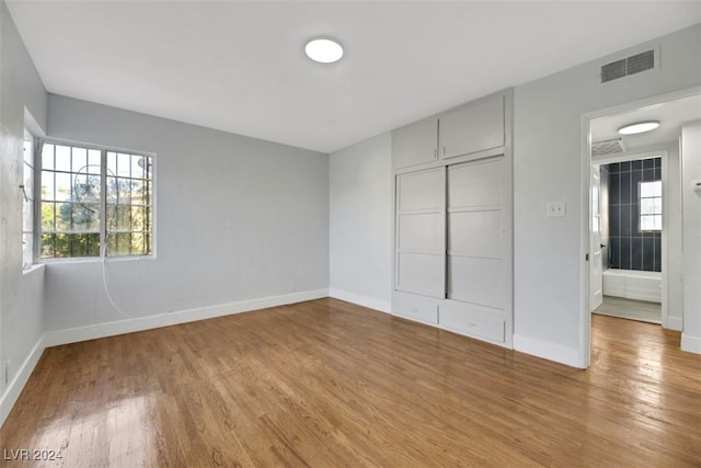 unfurnished bedroom with a closet and hardwood / wood-style flooring