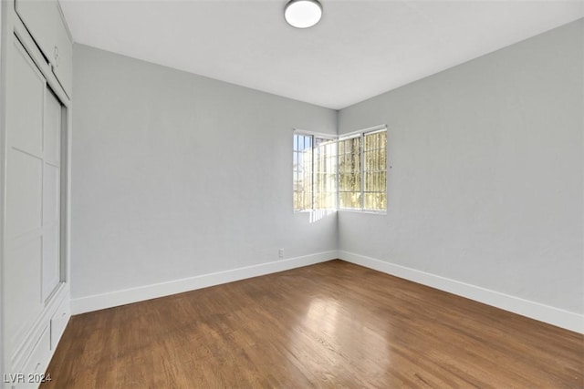 unfurnished bedroom with a closet and hardwood / wood-style floors