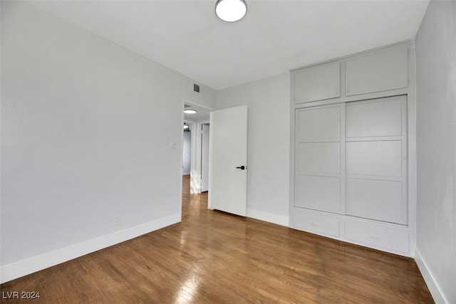 unfurnished bedroom featuring wood-type flooring and a closet